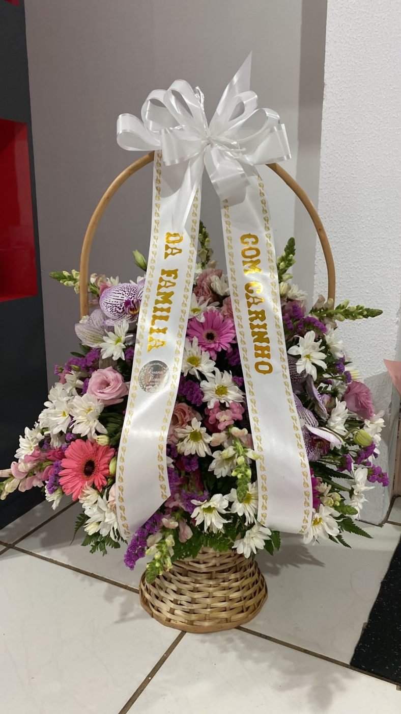 Arranjo floral em tons de rosa com faixa